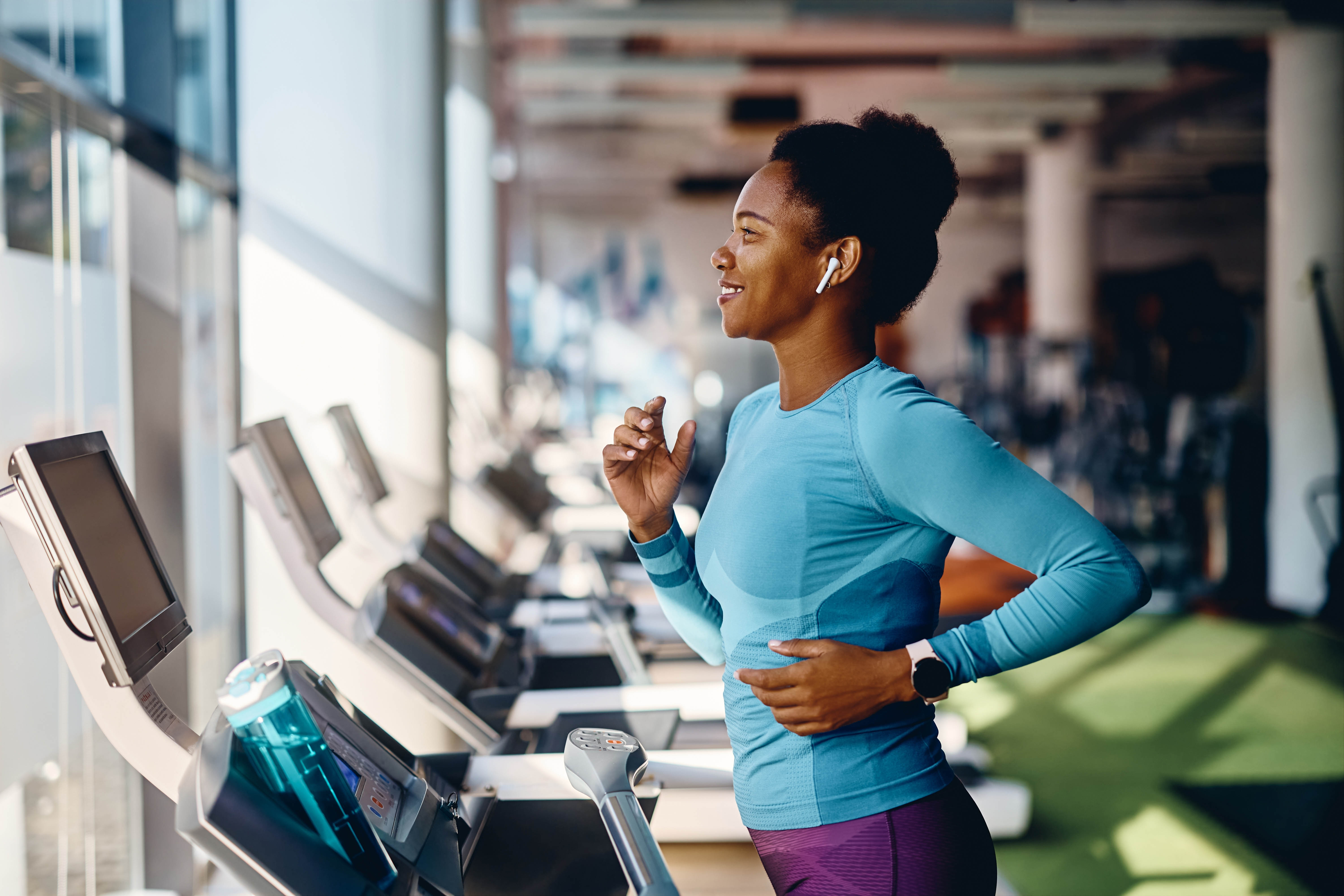 Middle aged woman running on a treadmill in an indoor gym/fitness club Middle aged woman running on a treadmill in an indoor gym/fitness club